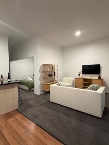 a living room with a white couch and a television at The Nook in Greytown