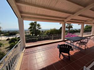 a patio with a table and chairs on a porch at Villa Bianca Plemmirio in Syracuse +7 photos