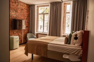 a bedroom with a bed and a brick wall at The Folks Hotel Konepaja in Helsinki +98 photos