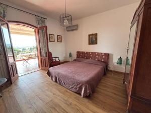 a bedroom with a bed and a sliding glass door at Villa Bianca Plemmirio in Syracuse