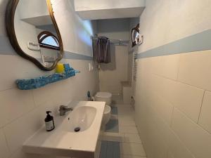 a bathroom with a sink and a mirror and a toilet at Villa Bianca Plemmirio in Syracuse