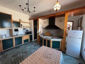 a kitchen with a table and a white refrigerator at Villa Bianca Plemmirio in Syracuse