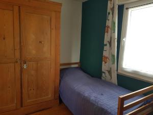 a bedroom with a bed and a cabinet and a window at Ferienwohnung Martino in Simmern