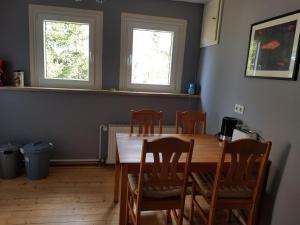 a dining room with a table and chairs and two windows at Ferienwohnung Martino in Simmern +2 photos