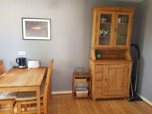 a dining room with a table and a wooden cabinet at Ferienwohnung Martino in Simmern