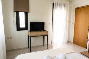 a bedroom with a bed and a television on a table at Venetia Luxurious Villa in Iraklitsa