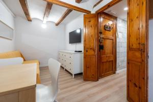 a living room with a wooden door and a television at Hauzify I Domus Tarragona in Tarragona