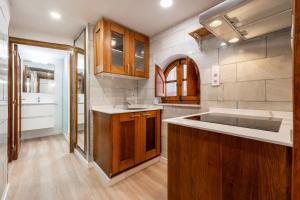 a kitchen with wooden cabinets and a sink at Hauzify I Domus Tarragona in Tarragona