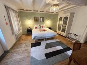 a bedroom with a white bed and a rug at SOLASI - Gîte et Chambres D'hôtes in Blanquefort-sur-Briolance