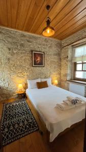 a bedroom with a large bed in a stone wall at SİSU ALAÇATI OTEL in Çeşme