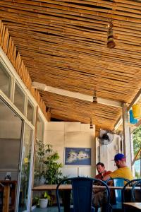 two men sitting at a table under a wooden ceiling at Lucy's Diner Hostel Cafe in San Francisco
