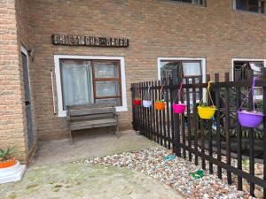 a fence with colorful buckets on it next to a building at Driftwood Haven in Mossel Bay