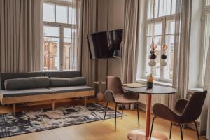 a living room with a couch and a table and chairs at The Folks Hotel Konepaja in Helsinki