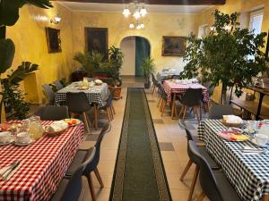 a restaurant with tables with red and white tablecloths at Zöldfa Panzió in Miskolc