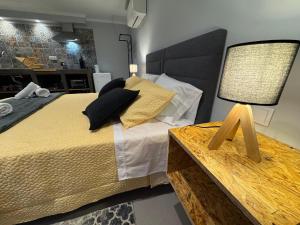 a bedroom with a large bed and a table with a lamp at Refúgio do Nevoeiro Estudio in Porto Moniz