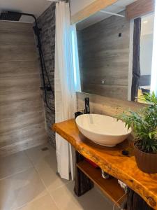 a bathroom with a white bowl sink on a counter at Refúgio do Nevoeiro Estudio in Porto Moniz +9 photos