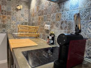 a kitchen with a juicer on a counter next to a sink at Refúgio do Nevoeiro Estudio in Porto Moniz