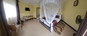 a bedroom with a bed with a canopy at Philo Leisure Gardens in Kalangala
