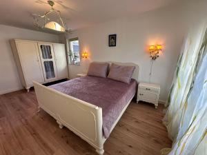 a bedroom with a bed with a purple bedspread at An der Elbe in Bad Schandau