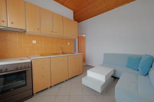 a kitchen with wooden cabinets and a blue couch in it at The Eden Hotel in Sarandë +61 photos
