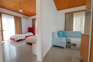 a living room with a couch and a bed and a room at The Eden Hotel in Sarandë