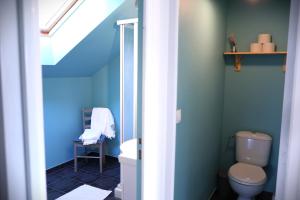 a bathroom with a toilet and a blue wall at Maison Mayjune Cottage in Irai