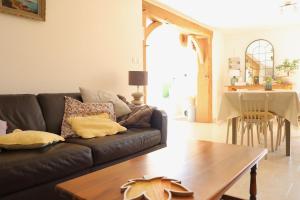a living room with a couch and a table at Maison Mayjune Cottage in Irai