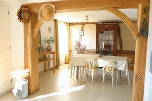 a dining room with a white table and chairs at Maison Mayjune Cottage in Irai