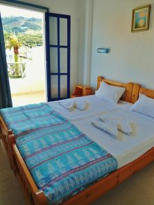 a bedroom with a large bed with a large window at Apollonia Apartments in Agia Pelagia