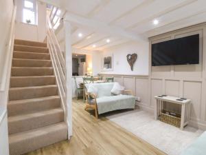 a living room with stairs and a flat screen tv at 27 Kingshead Street in Pwllheli