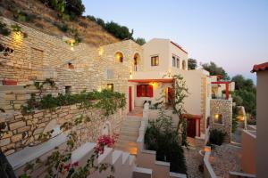 a building with stairs and a stone wall at Stefanos Village Hotel in Plakias