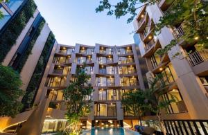 a large building with a pool in front of it at quintara arte 52,on nut in Bangkok