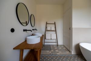 a bathroom with two sinks and a mirror at La Maison et l'Orangerie in Saint-Jean-des-Vignes +21 photos