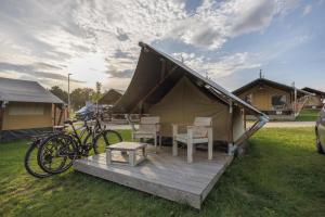 a tent with bikes and a table and chairs at Sonnenkap Camping in Prenzlau