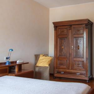 1 dormitorio con armario de madera junto a la cama en B&B Borgo San Vito, en Ronchi dei Legionari