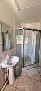 a bathroom with a toilet and a sink and a shower at Marli Guesthouse Self-Catering in Welkom +49 photos