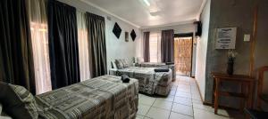 a hotel room with two beds and a window at Marli Guesthouse Self-Catering in Welkom