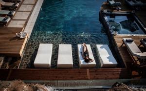 an overhead view of a swimming pool with chaise lounges at Elounda Orama by GHH in Elounda
