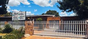 a white picket fence in front of a building at Marli Guesthouse Self-Catering in Welkom
