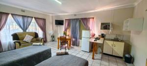 a bedroom with a bed and a living room at Marli Guesthouse Self-Catering in Welkom
