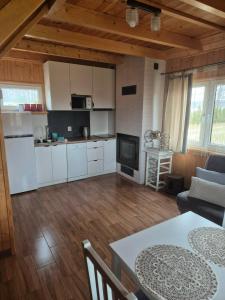 a kitchen and living room with a table and chairs at Dreamland skorupki in Ryn
