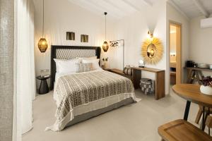 a bedroom with a bed and a table and a mirror at Aether-Castle vista in Monemvasia