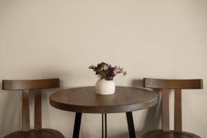 a table with two chairs and a vase with flowers on it at Aether-Castle vista in Monemvasia