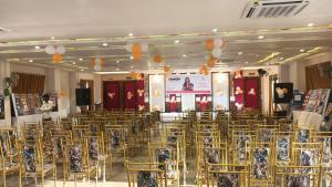 a room with a bunch of chairs and a stage at Narayan resort and restaurant in Aklera