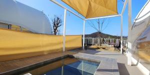 a swimming pool in a pavilion with a yellow roof at The Hill Glamping in Yeoju