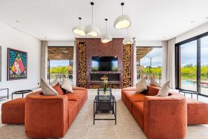 a living room with two orange couches and a tv at Citrus Bloom Manor Marrakech in Oulad Mazoug