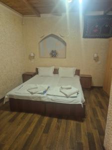 a bedroom with a bed with two towels on it at HOTEL Rahmon - 2 in Samarkand