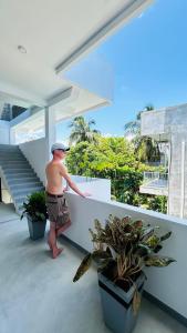 a man standing on the balcony of a house at Saffron Swell Villa in Arugam Bay