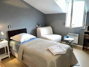 a bedroom with a bed and a chair and a window at Greg House 49 - Chambres d'Hôtes in Beaupréau