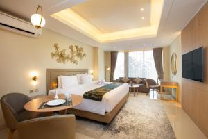 a hotel room with a bed and a table and chairs at Louis Kienne Hotel Cikarang in Cikarang